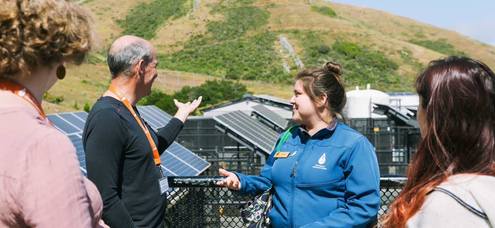 an educator talks to guests on the observation deck during an event