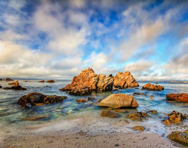 Monterey Bay rocky coastline with blue skies and clouds