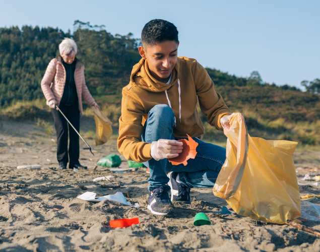 young man and older woman doing a beach cleanup