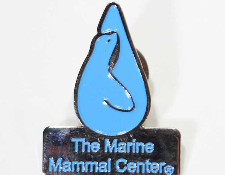 blue lapel pin in shape of The Marine Mammal Center logo