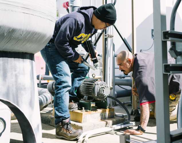 two facilities team members work near the filtration systems
