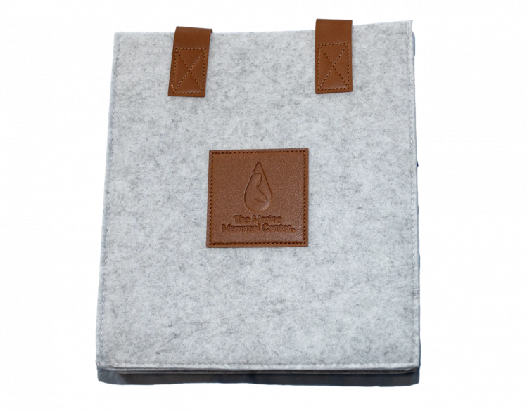 A gray felt and faux leather 3 bottle wine bag with The Marine Mammal Center logo