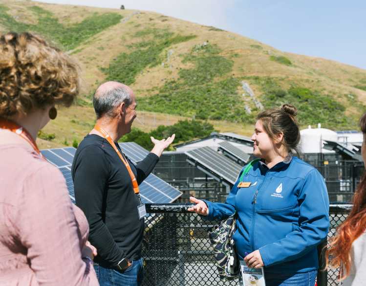 An educator leads a tour with patient pens in the background