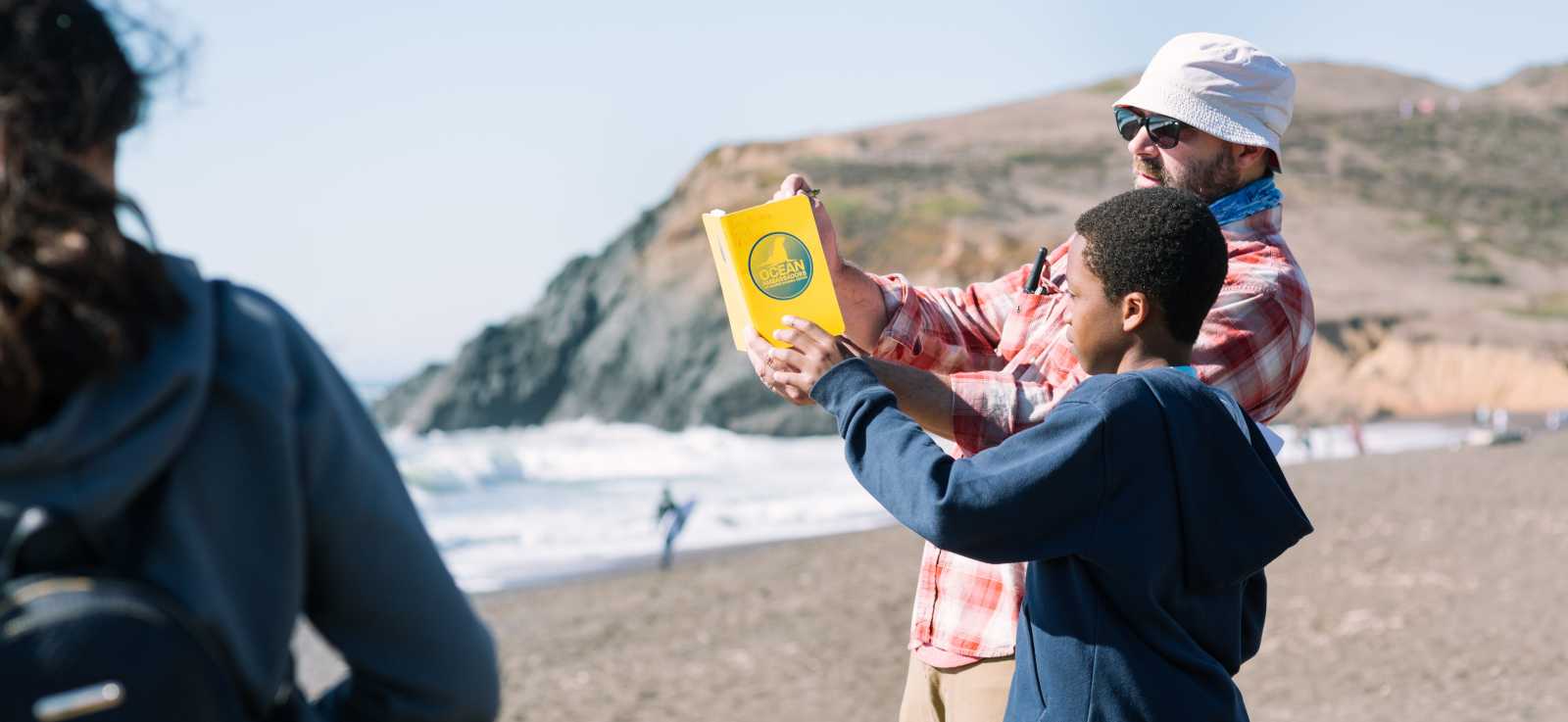  a teacher and student work together making observations at the beach